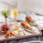 Style your home like a pro with breakfast in bed with orange juice and croissants