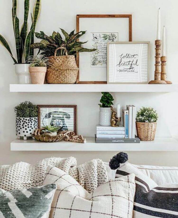 The living room shelves hold books, plants, and framed artwork.