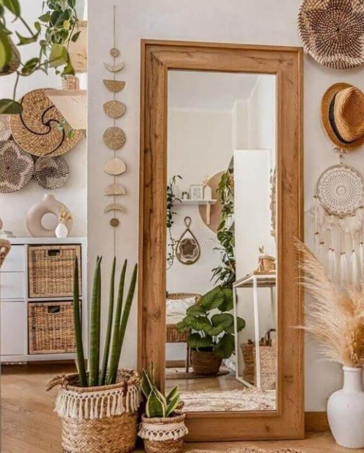 A wooden mirror surrounded by rattan and wicker baskets and decor elements.