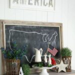 Chalkboard with United States line art on a shelf with other 4th of July décor.