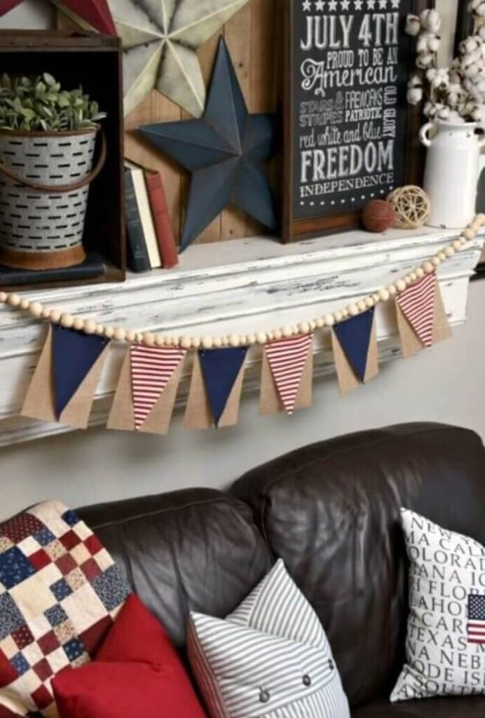 A DIY flip banner on a distressed white mantel with farmhouse 4th of July décor.