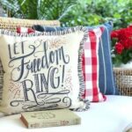 4th of July "Let Freedom Ring" throw pillows on an outdoor bench.