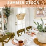 Summer décor farmhouse style table setting with copper dishes, faux greenery centerpiece, and glass chandelier.