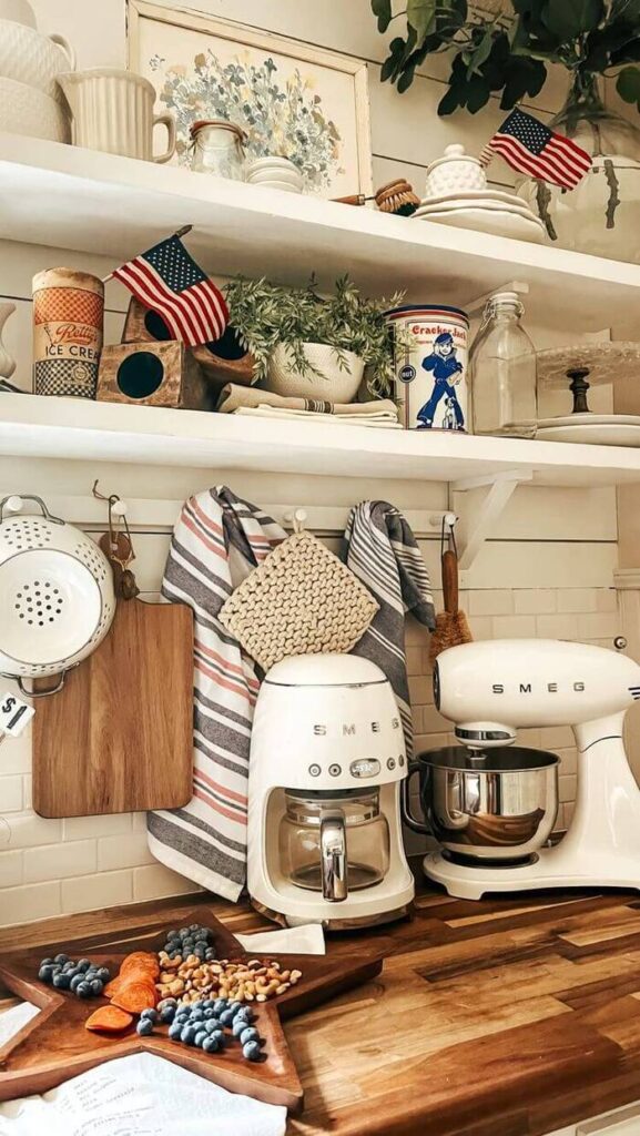 Kitchen counter with white appliances and 4th of July décor and tea towels.