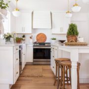 white farmhouse kitchen with wood floor and wood barstools with tips to save on a remodel