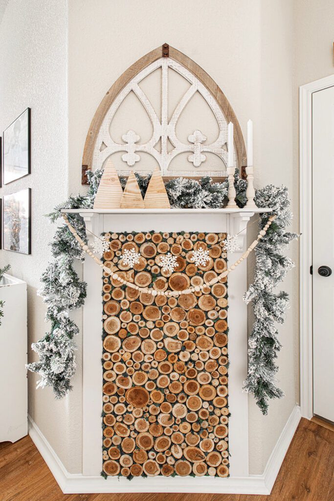 wood filled fireplace with garland