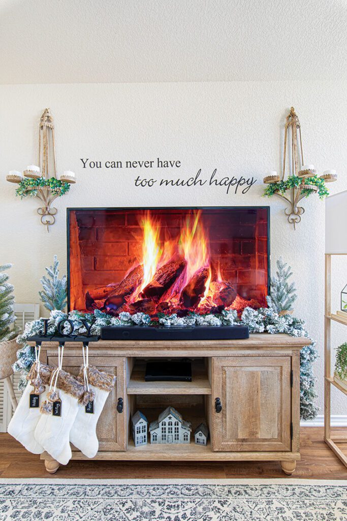 tv cabinet with garlands and white stockings in festive Texas home