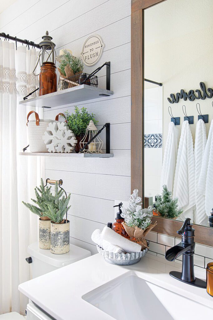 farmhouse bathroom with shiplap walls and festive greenery