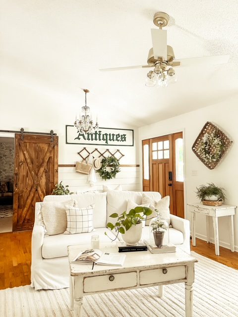 Jessica Sigmon and her living room with farmhouse decor and a barn door to the bedroom