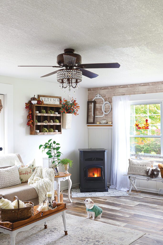 vintage style fireplace, jeweled ceiling fan in farmhouse living room