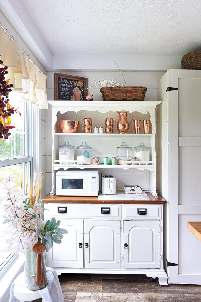 hutch with copper pitchers in farmhouse kitchen