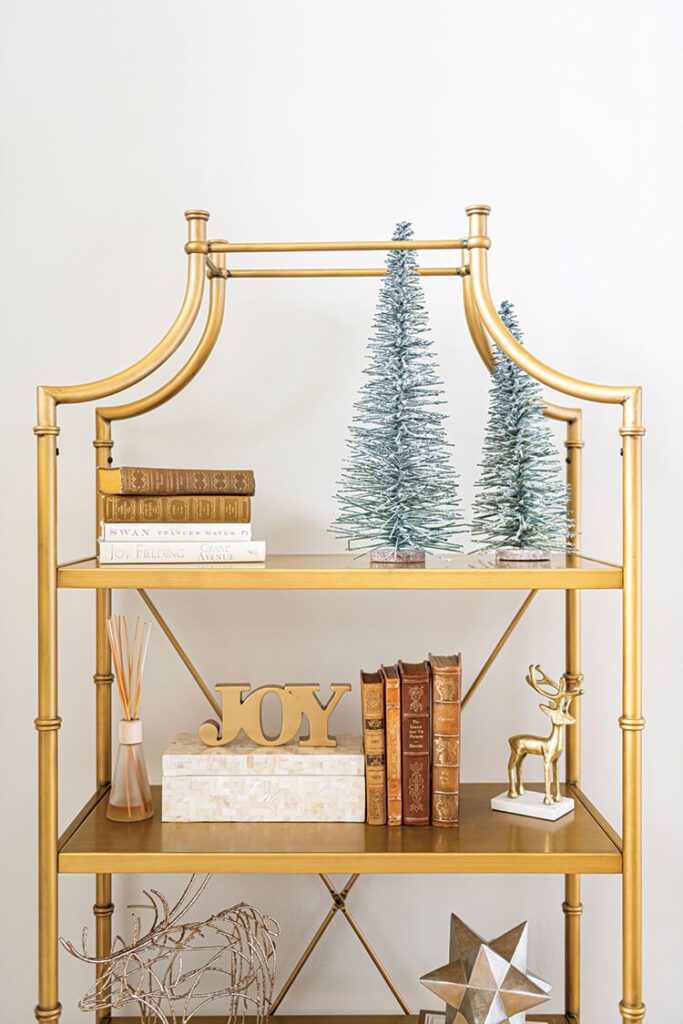 bookshelf with bottlebrush trees and gold accents for Christmas