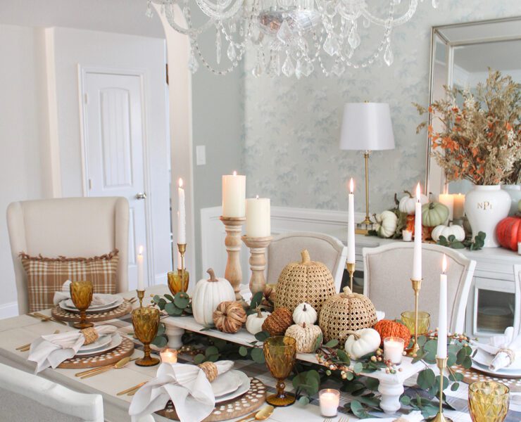 Blue dining room with Thanksgiving tablescape and pumpkins on a raise platform