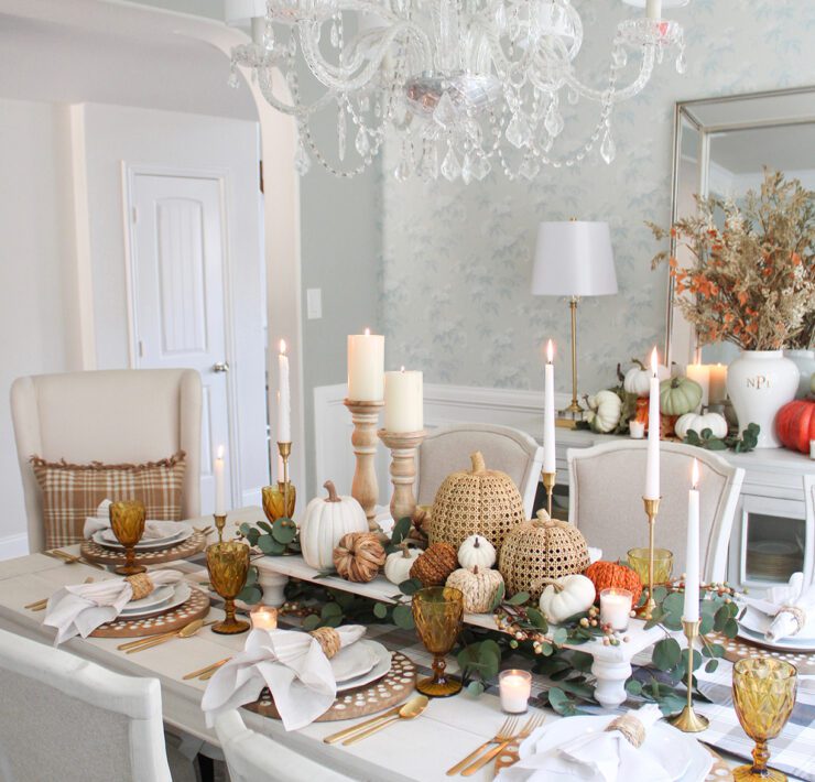 Blue dining room with Thanksgiving tablescape and pumpkins on a raise platform