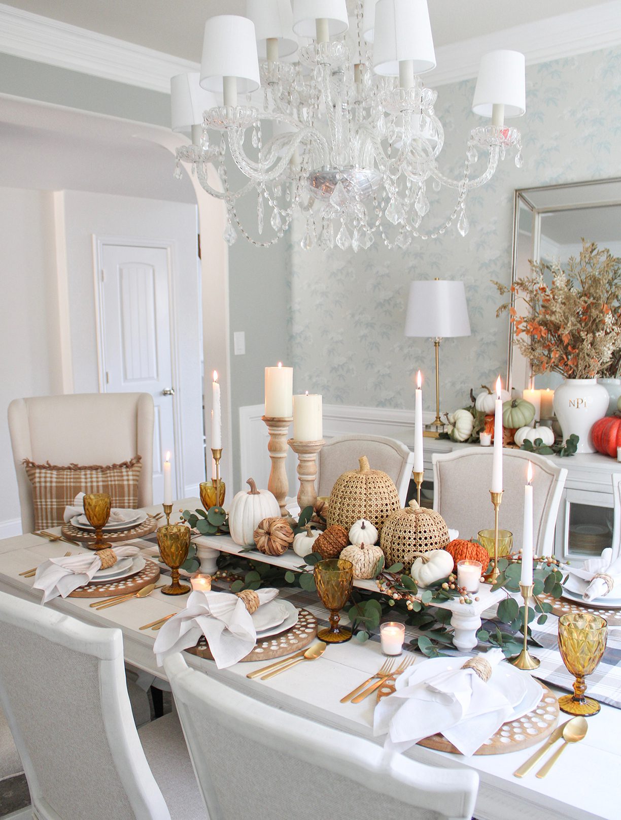 Blue dining room with Thanksgiving tablescape and pumpkins on a raise platform