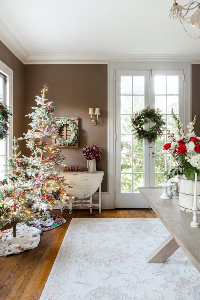 planning for a christmas party dining room with tree wreath and red and white roses