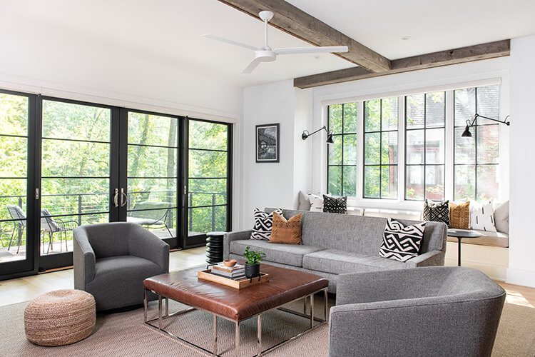 A mostly white interior with dark metal stairwell railing and a wood bannister