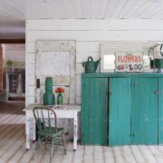 Living room with shiplap walls, old furniture and teal accents