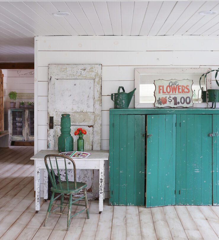 Living room with shiplap walls, old furniture and teal accents