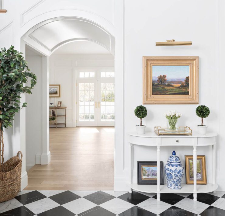 Foyer with black and white checkered tile and wainscoting, one of the interior design trends of 2023
