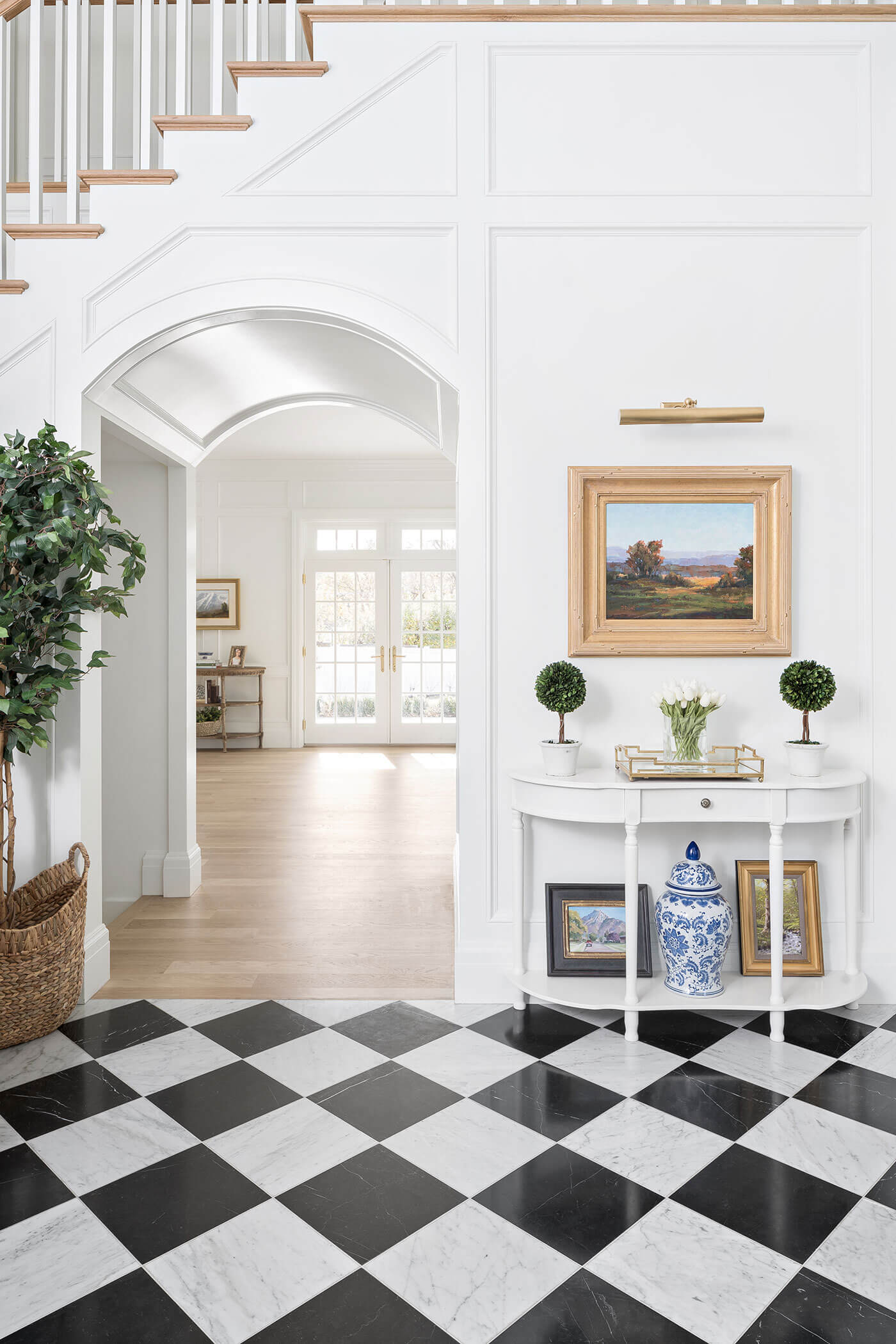 Foyer with black and white checkered tile and wainscoting, one of the interior design trends of 2023