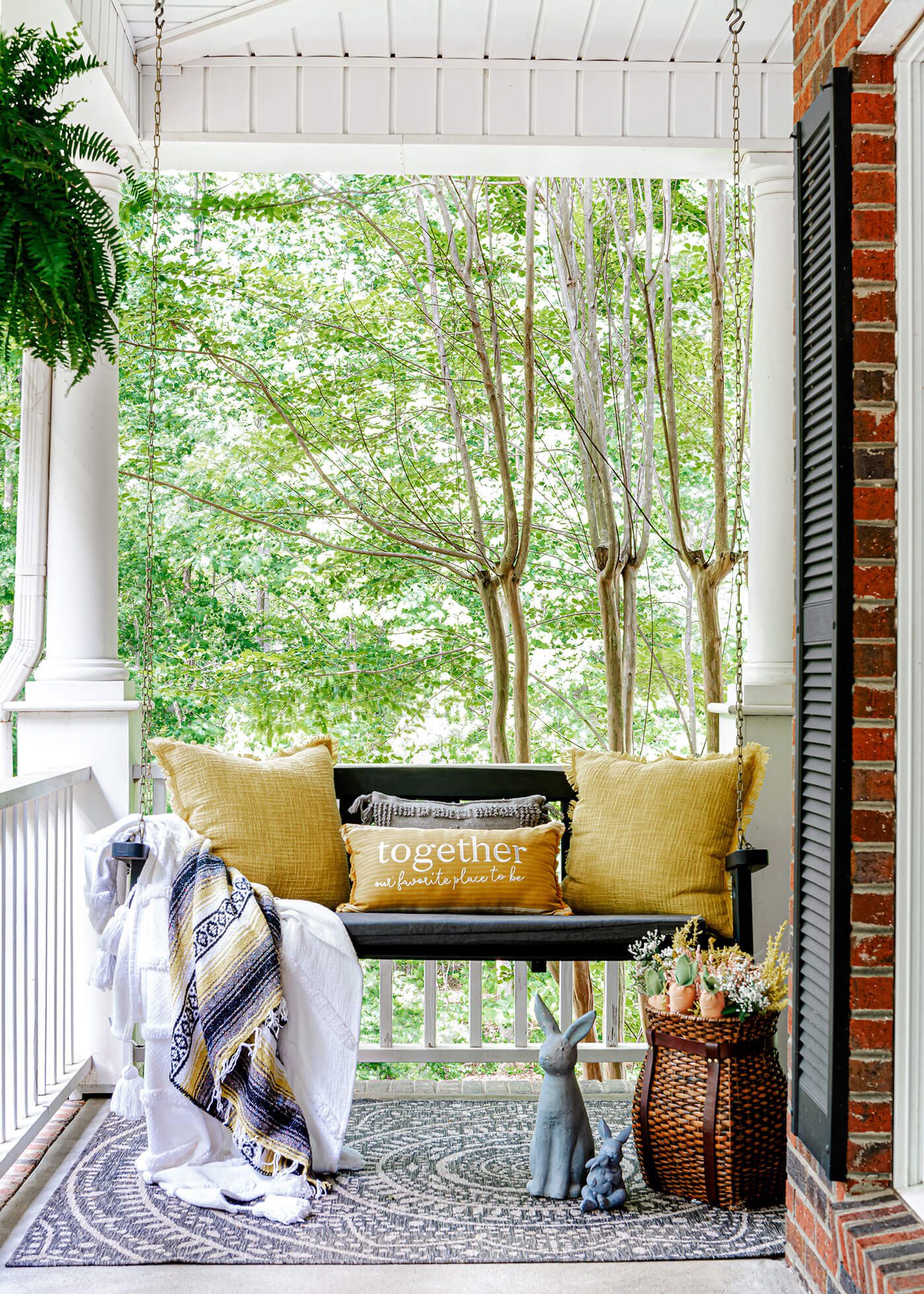 Covered porch with hanging swing and outdoor spring decorating