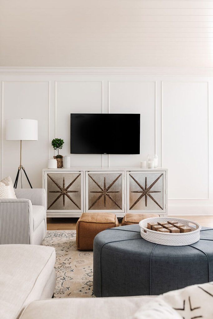 Living room with white paneled walls, starburst TV cabinet and black TV
