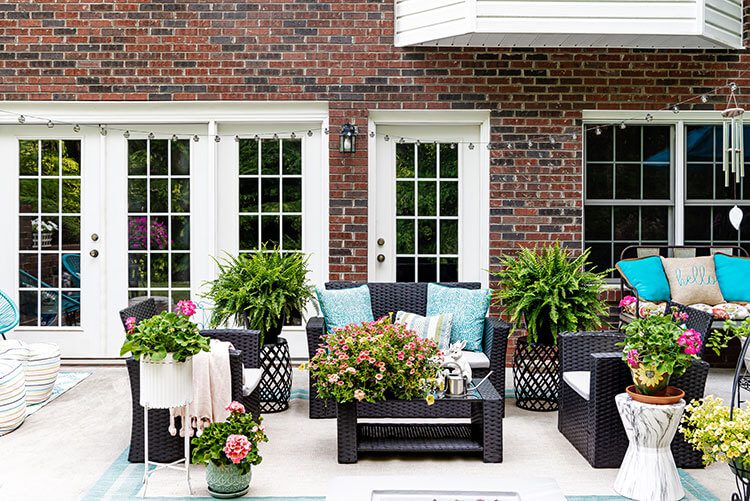 Outdoor patio area with black furniture and fresh flowers