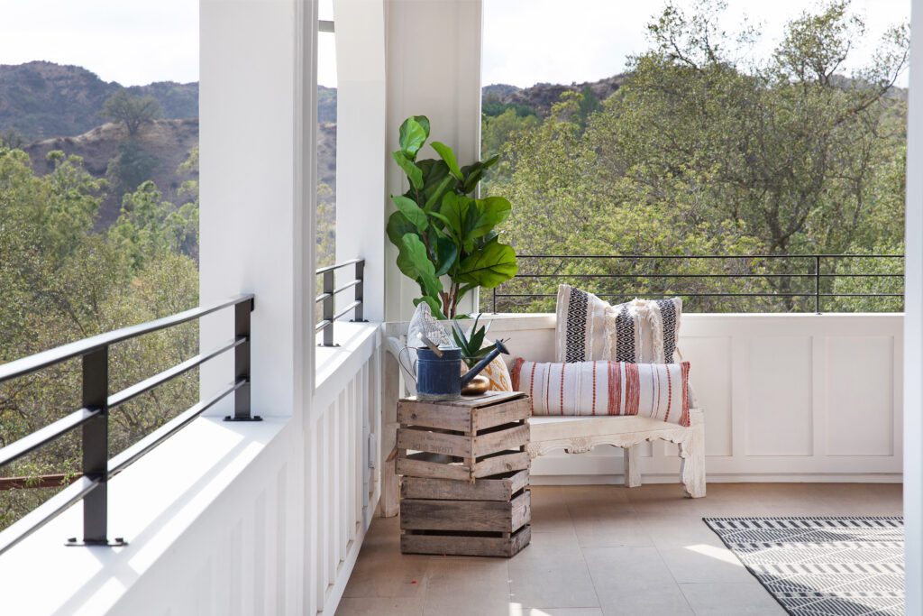 With its open beam ceiling and tiled floor, the deck offers an interesting farmhouse perspective that looks out on green trees in the canyon.