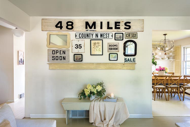 neutral gallery wall of mirrors and vintage signs