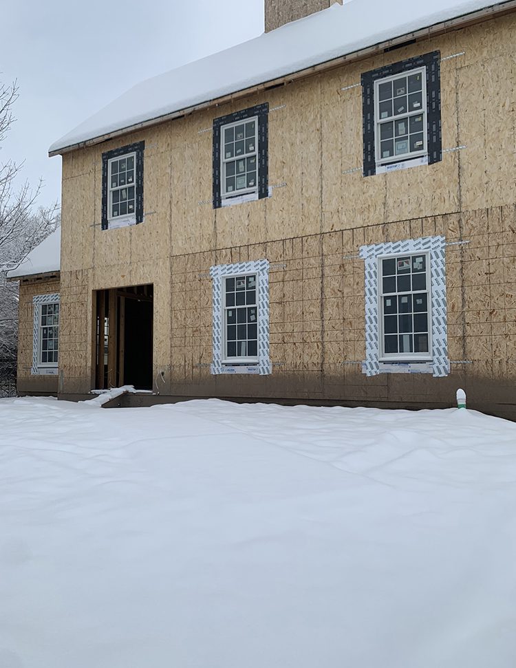 Snowy exterior of a home halfway built