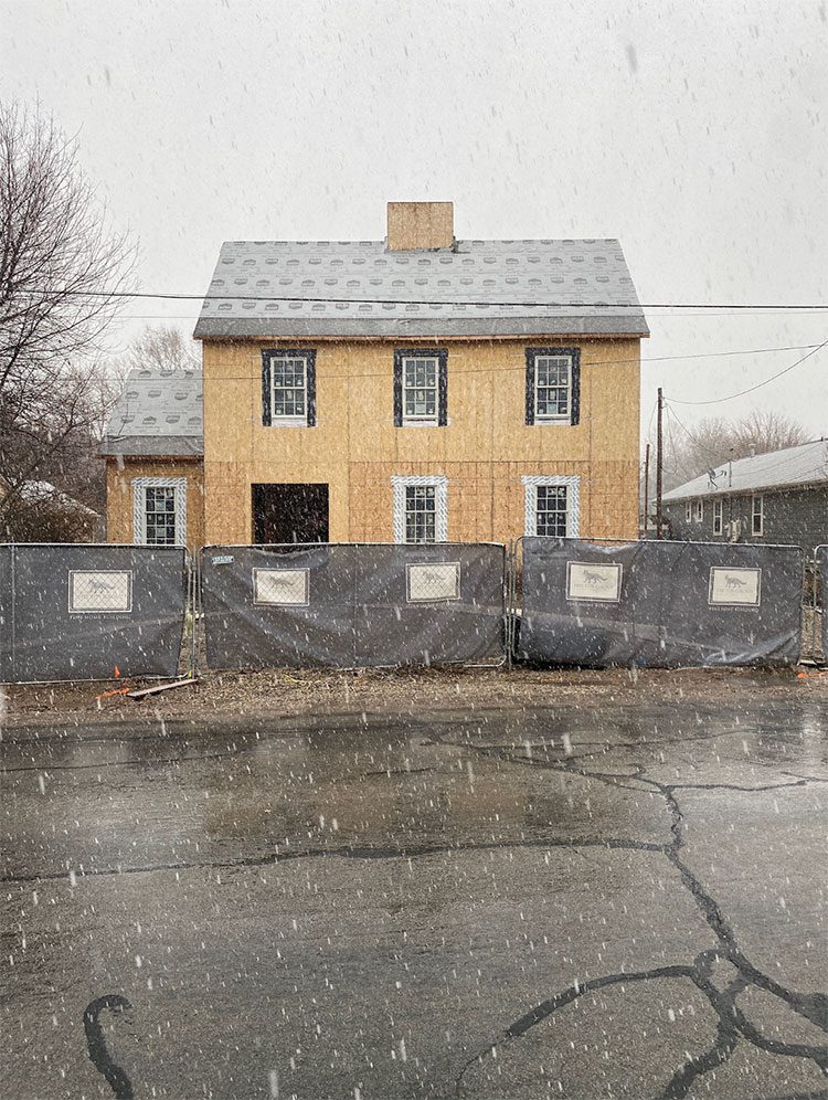 Snowy exterior of a home halfway built with renovation setbacks