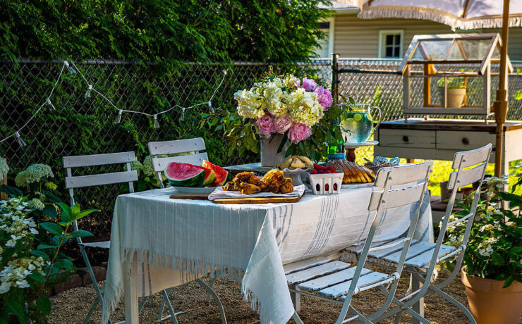 outdoor dining table set with flowers and summer watermelon and fried chicken