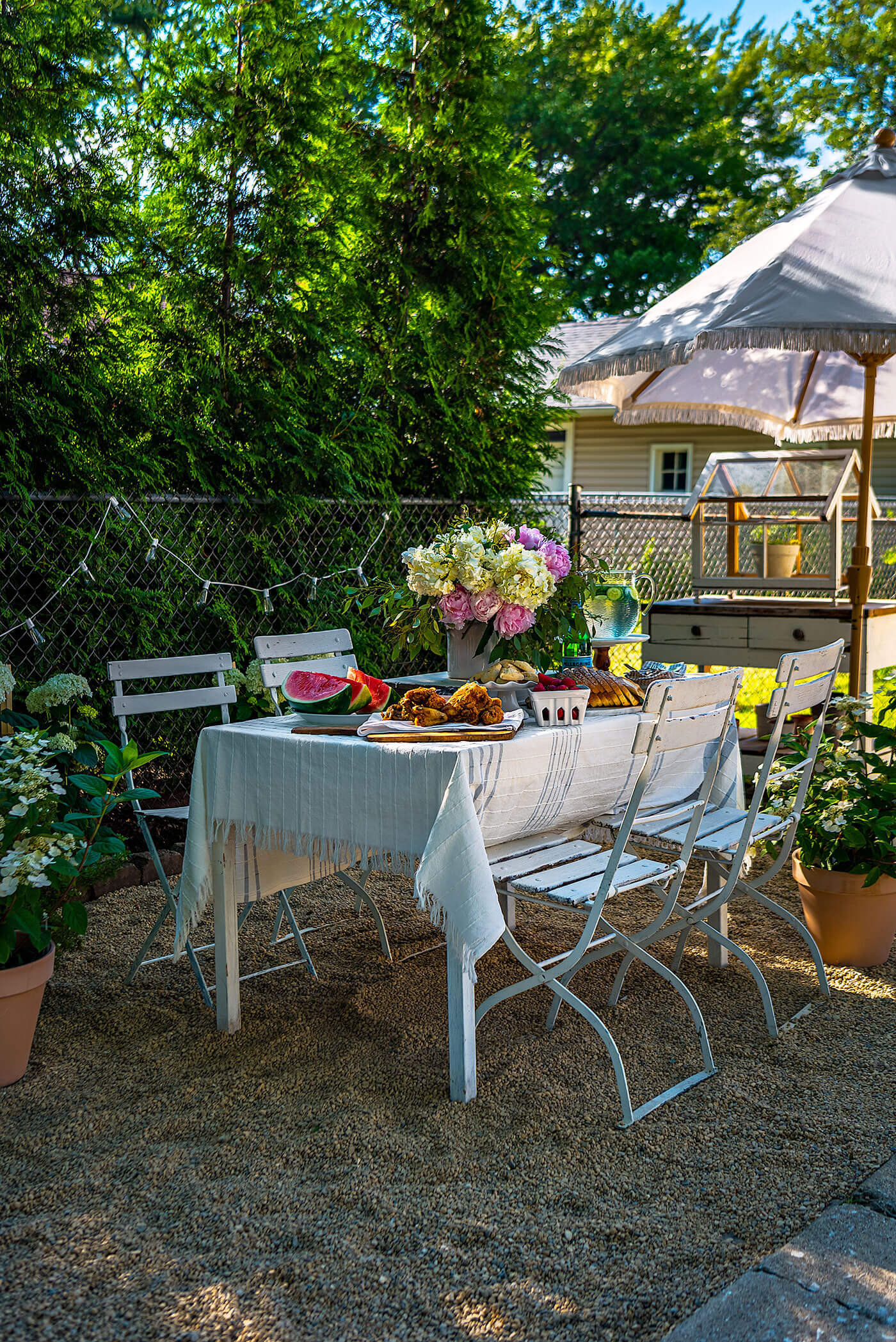 outdoor dining table set with flowers and summer watermelon and fried chicken