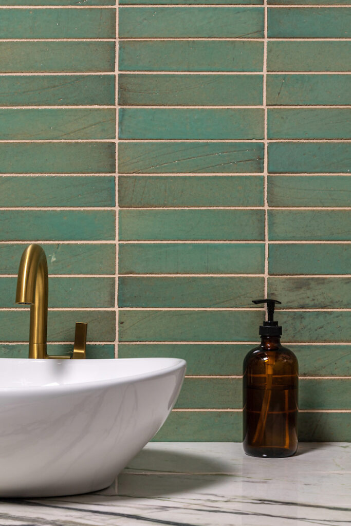 rectangular green bathroom backsplash tile behind vessel sink