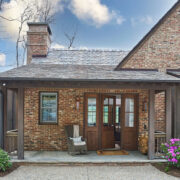 Exterior of rustic farmhouse with flowers and wood front door