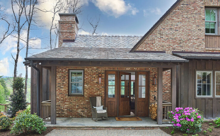 Exterior of rustic farmhouse with flowers and wood front door