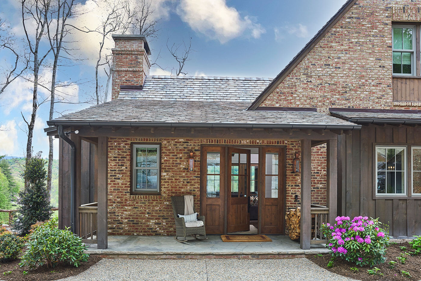 Exterior of rustic farmhouse with flowers and wood front door