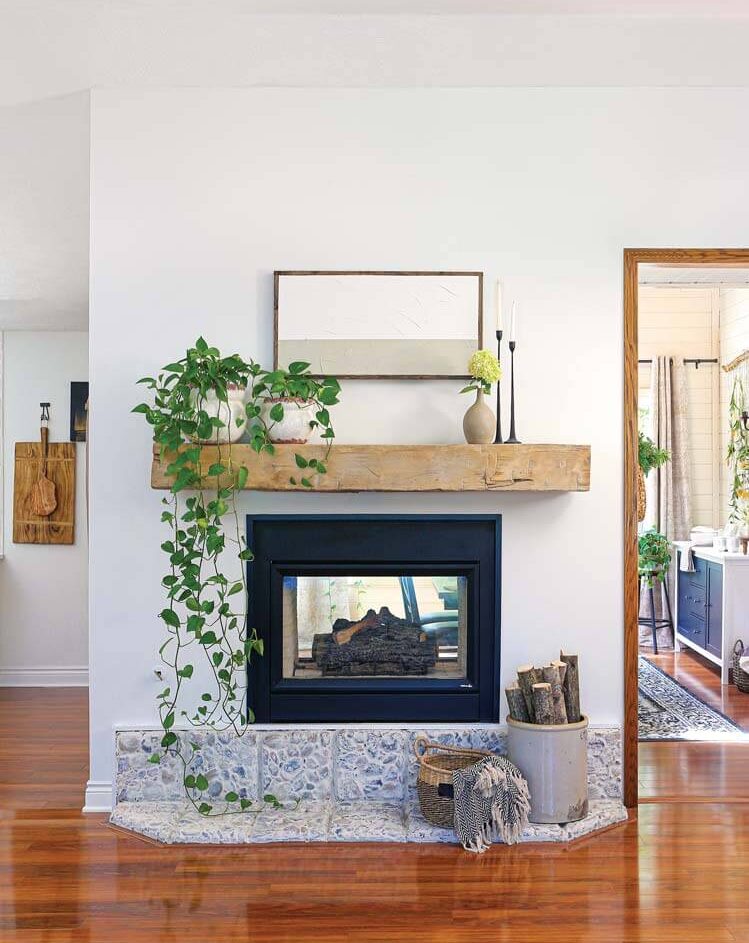 fireplace with natural wood mantle and hanging plants