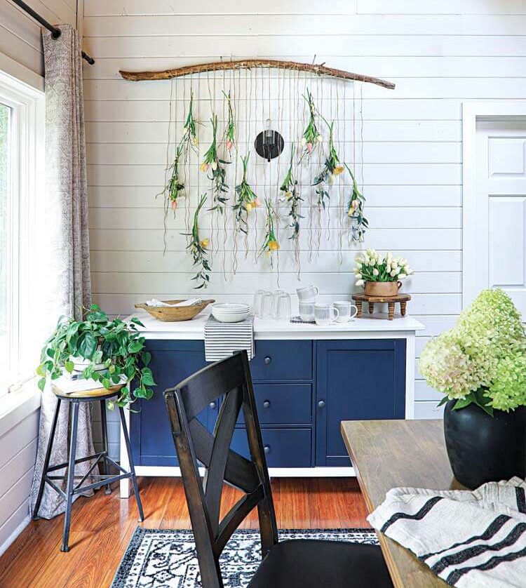 branch art hanging tulips and navy blue and white sideboard