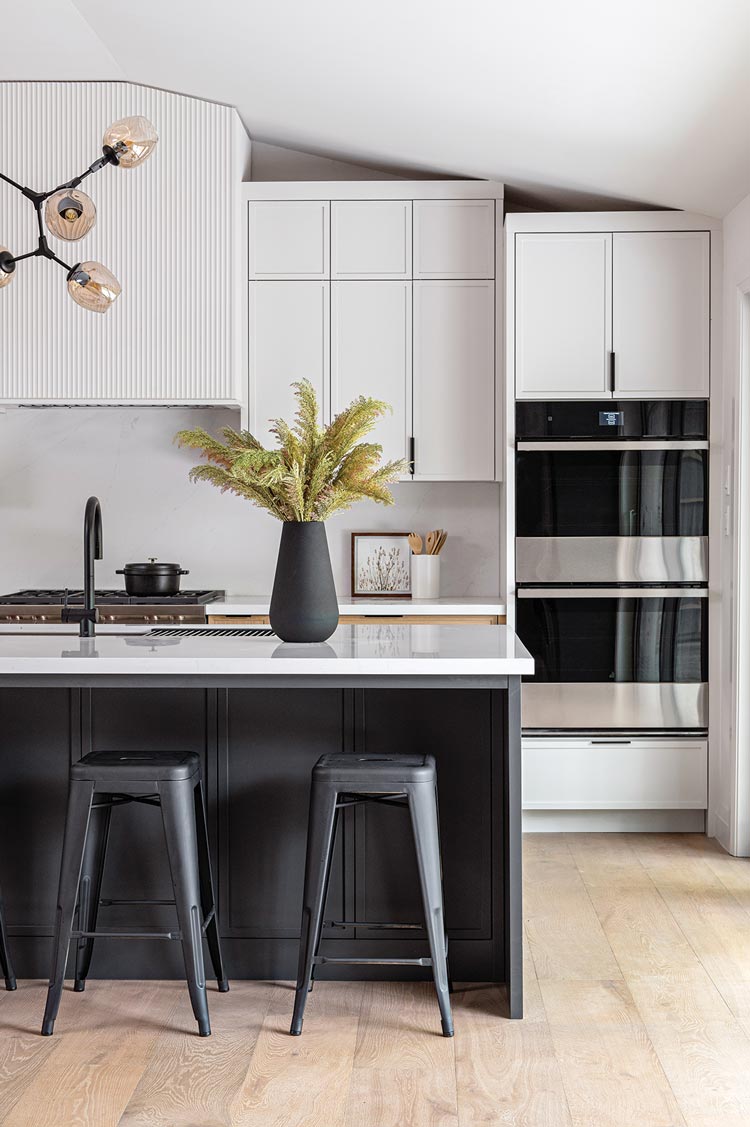 kitchen with black island and faucet with built-in stoves