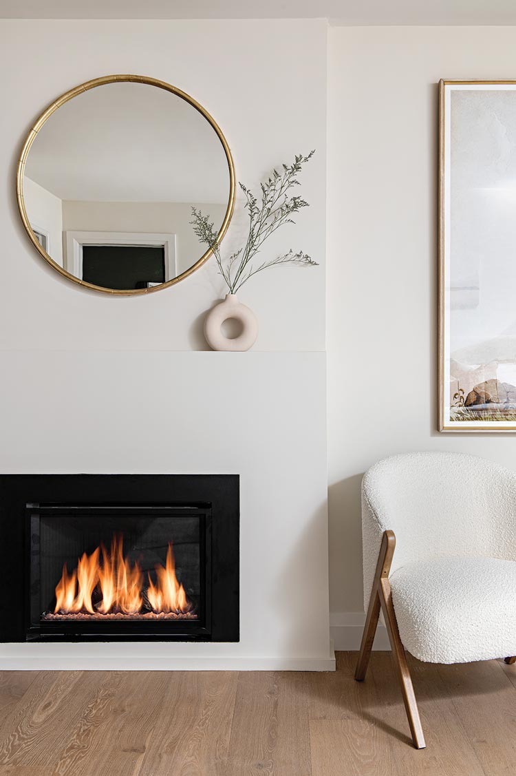 rounded mirror and vase on white mantel in Scandinavian inspired home