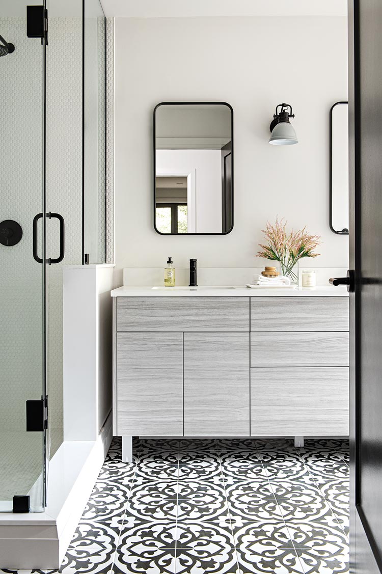 black and white mosaic tile and black fixtures in bathroom