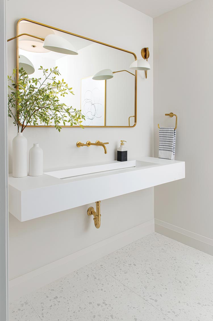 floating bathroom sink and large mirror with rounded edges in powder room