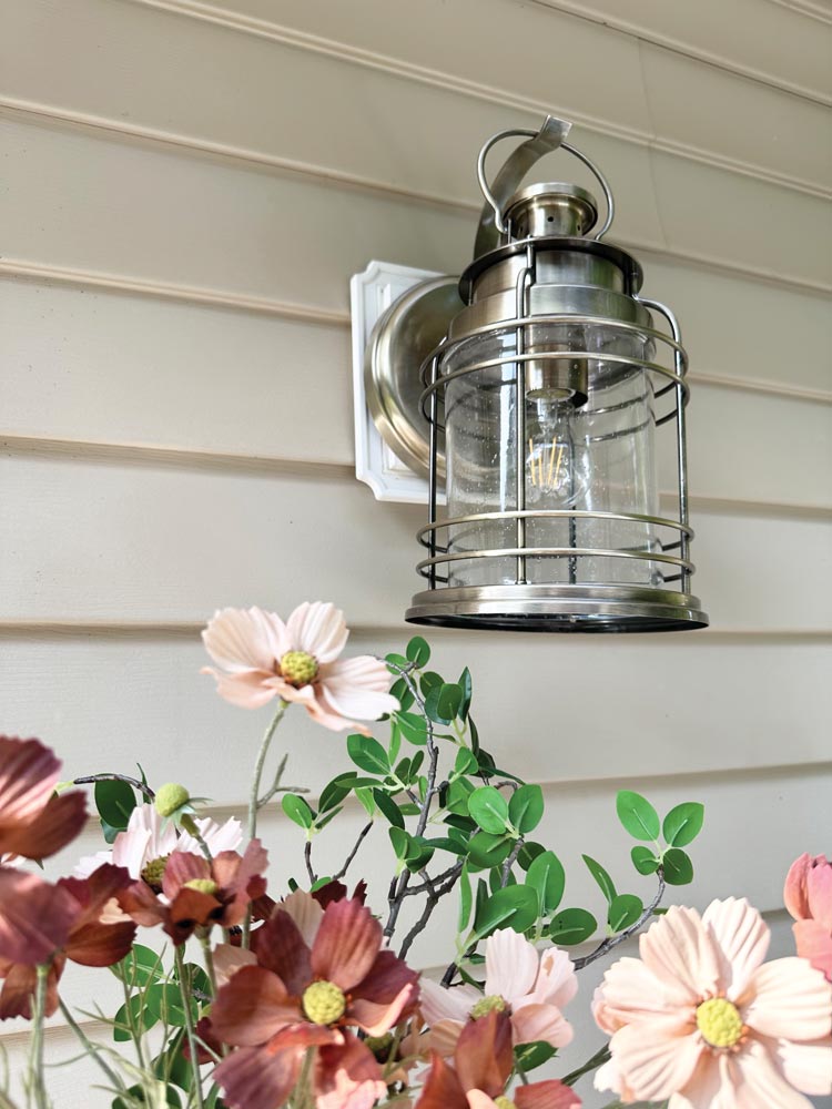 flowers underneath exterior lantern style wall sconce