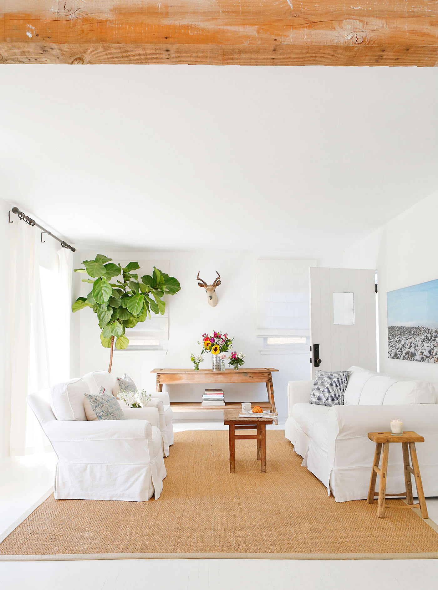 White living room with coastal farmhouse decor and art