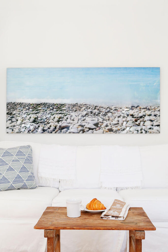 White sofa with vivid blue coastal farmhouse art on the wall