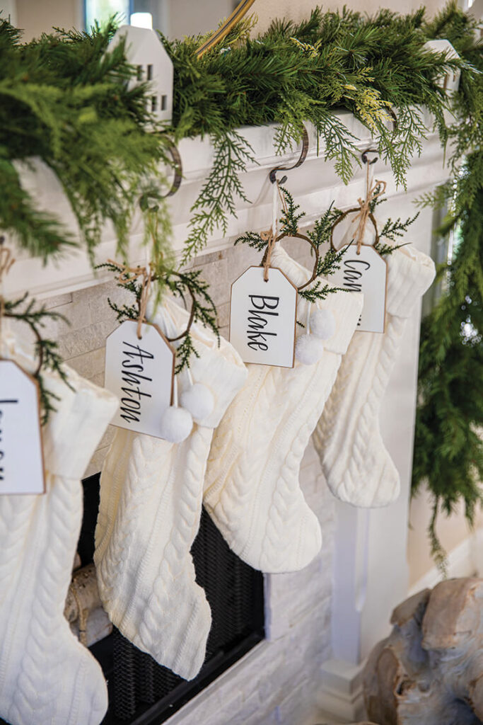 cream colored stockings hanging from mantel with cedar and pine wreath