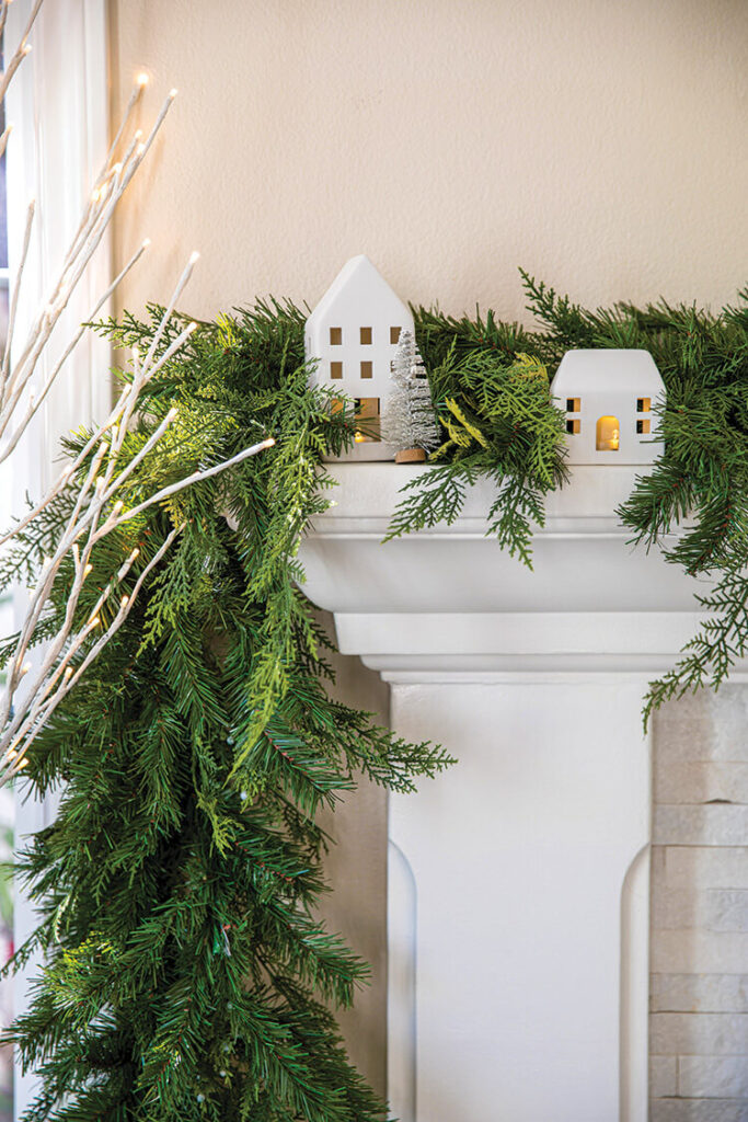 mantel with cedar and pine garlands and white mini houses