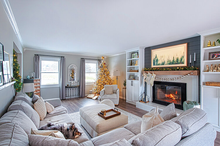 living room with ornament garland on mantel and lighted Christmas tree